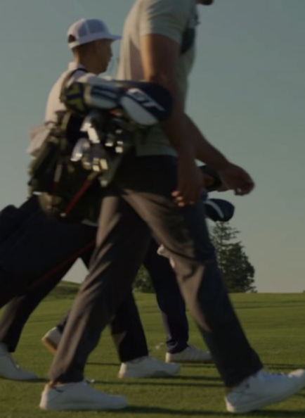 Golfers walking the fairway carrying bags